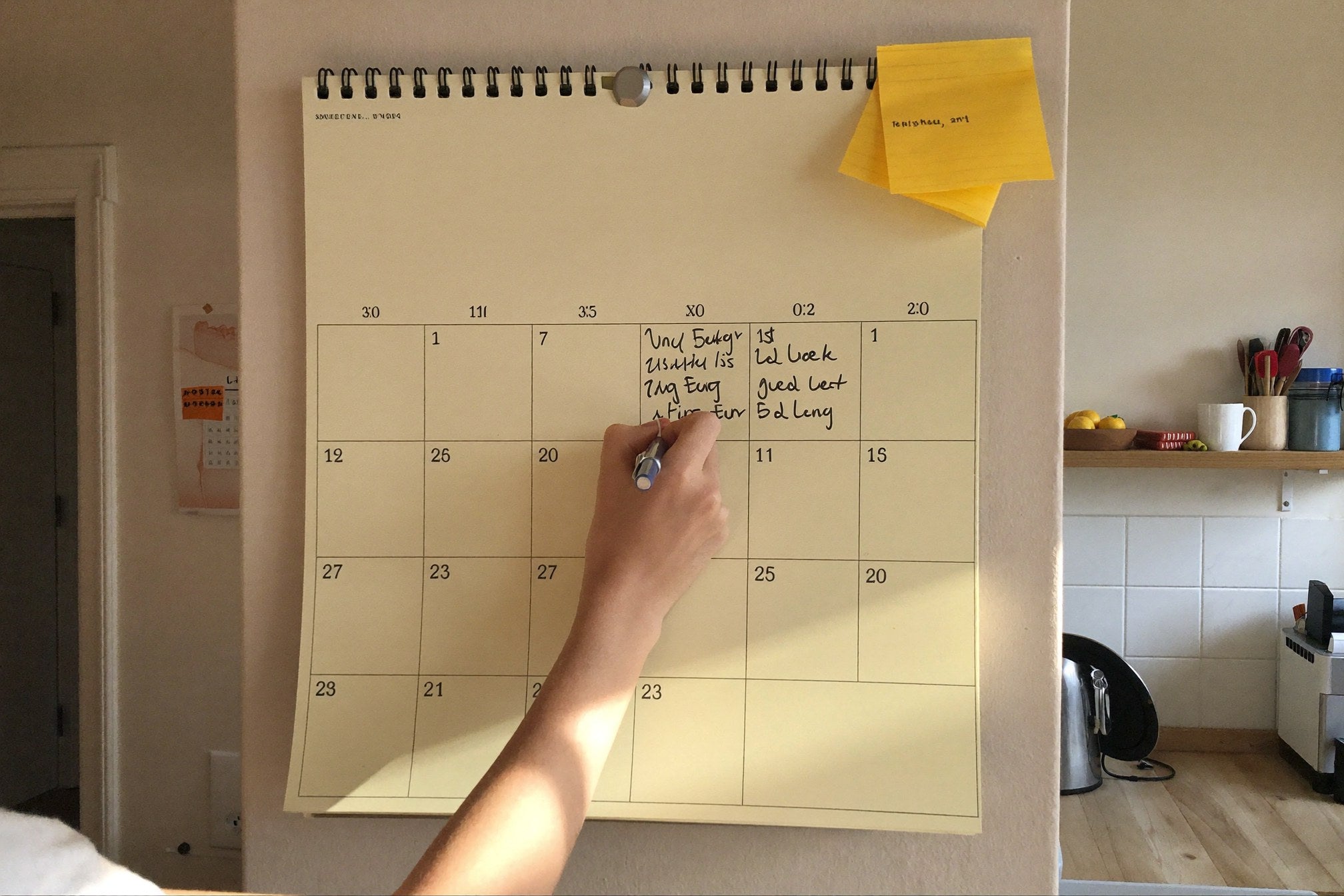 A family calendar on the kitchen wall